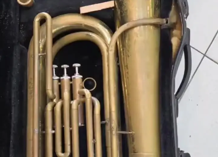 A mesma tuba antes da reforma, sem brilho e amassada